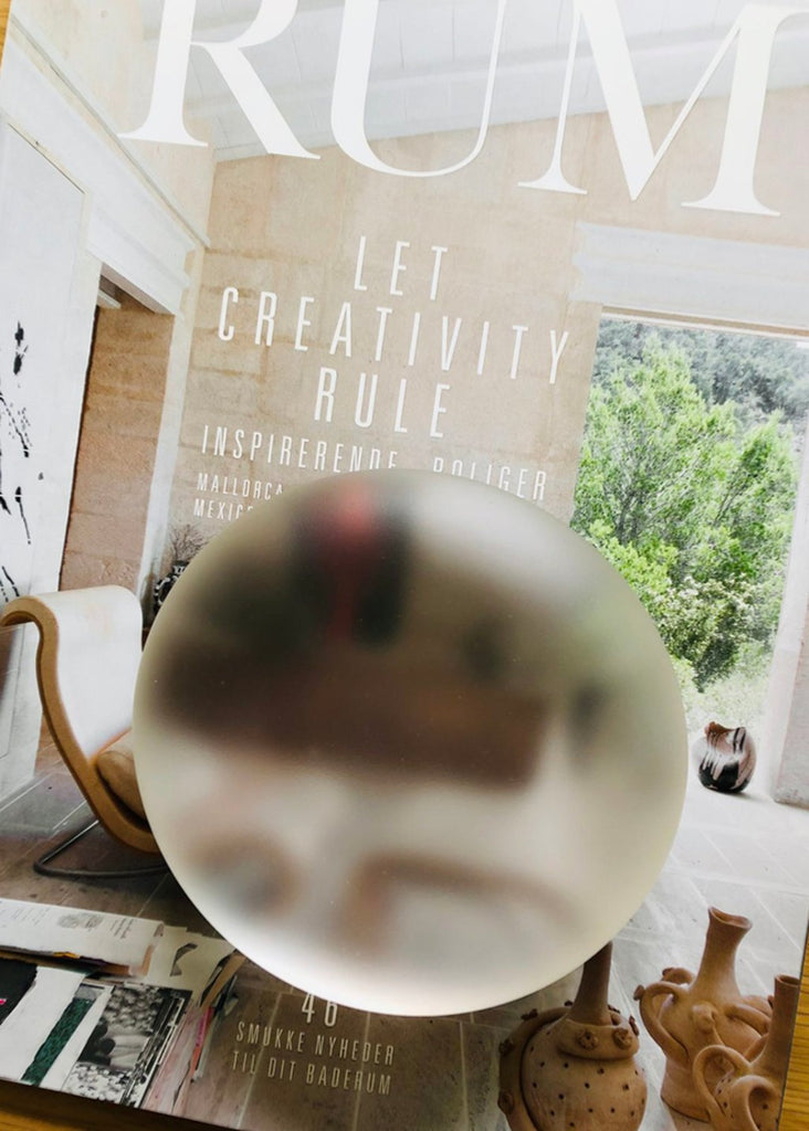 Mia Lerssi transparent handmade Solid Glass Piece on top of a magazine